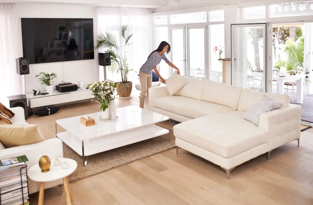 Bright living room with a white sectional sofa and large windows