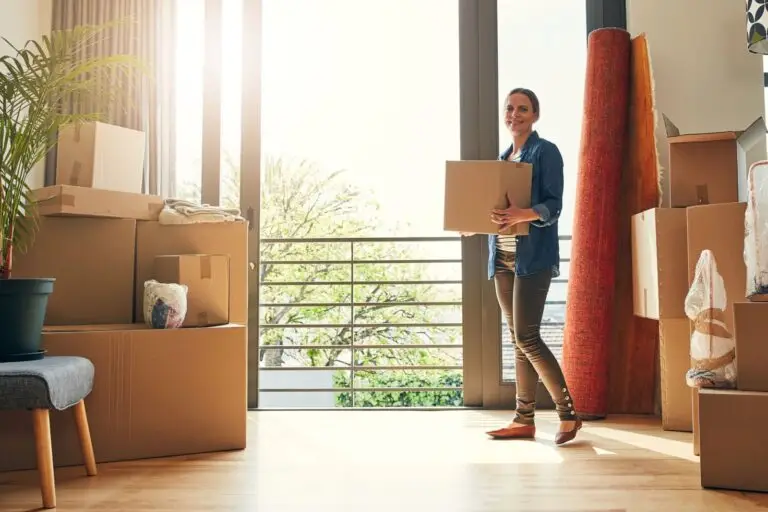 Woman carrying a moving box into her new home