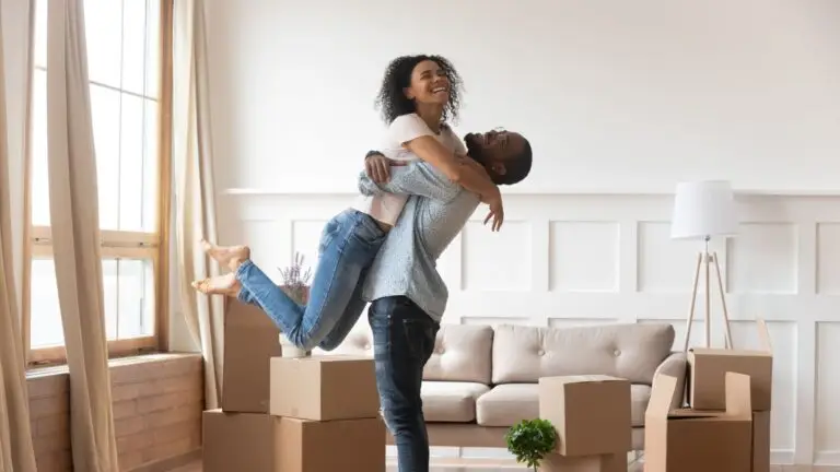 Couple celebrating in the living room of their new home