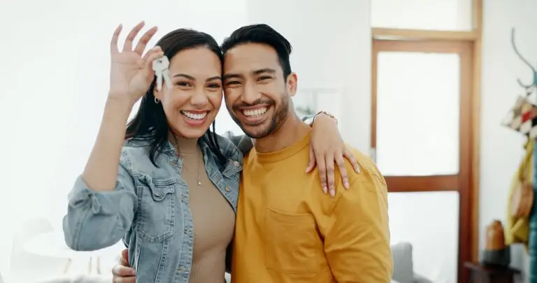 Smiling couple holding up the keys to their new home
