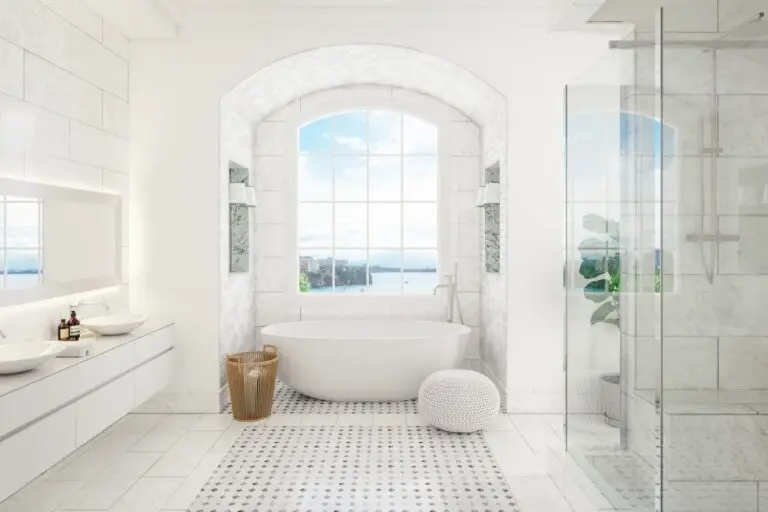 Bright white bathroom with a freestanding tub below an arched window