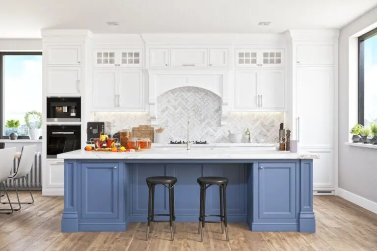 White kitchen with a navy blue island and two black bar stools