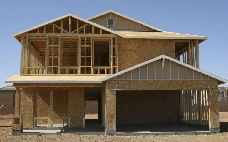 Two story home under construction with framed walls and an open garage