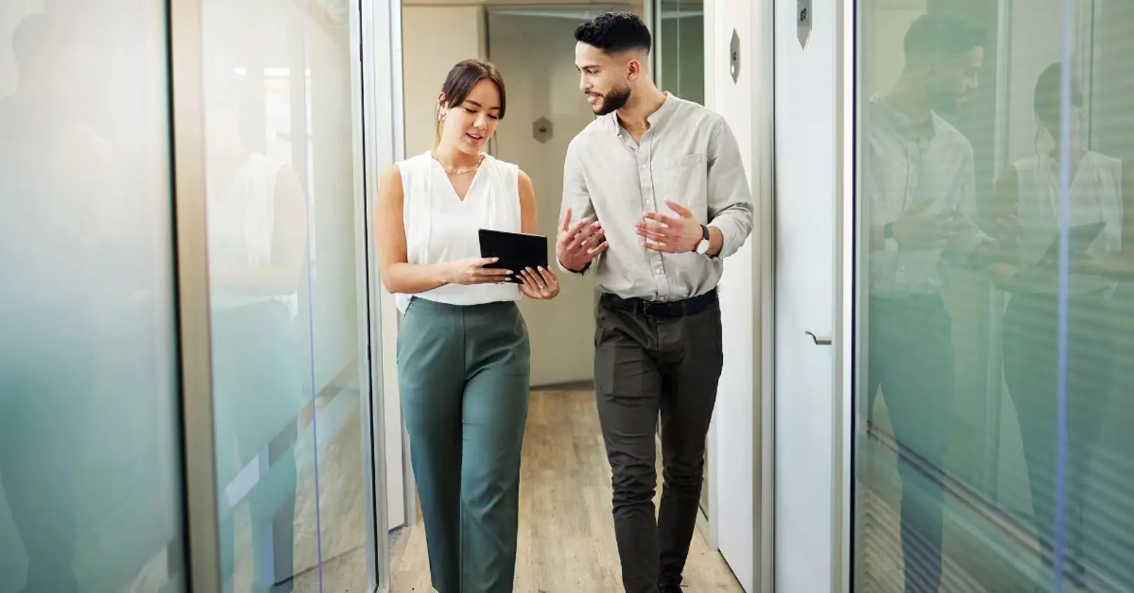 Two loan officers walking through a modern office